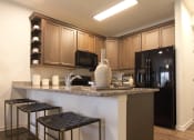 Thumbnail 10 of 36 - a kitchen with a bar and stools  at Carillon Woods, Millsboro