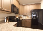 Thumbnail 11 of 36 - a kitchen with black appliances and wood cabinets  at Carillon Woods, Delaware, 19966