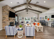 Thumbnail 4 of 31 - A living room with a stone fireplace and striped chairs.