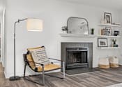 Thumbnail 4 of 27 - A living room with a chair, a fireplace, and a floor lamp. at Eagle Ridge Apartments, Monroeville, PA, 15146