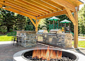 Thumbnail 27 of 28 - a backyard with a barbecue grill and a fire pit at The Ledges Apartment Homes, Connecticut