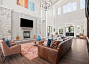 Thumbnail 18 of 28 - A living room with a stone fireplace and a brown leather couch.