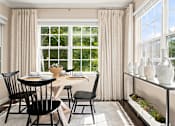 Thumbnail 6 of 28 - A dining room with a table set for two and a window with curtains.