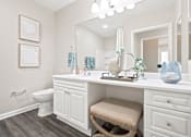 Thumbnail 11 of 28 - A bathroom with a white vanity and a white toilet.