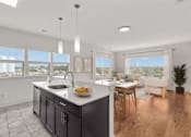 Thumbnail 4 of 15 - A modern kitchen with a large island and a dining area.