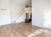 Thumbnail 14 of 26 - an empty living room with wood floors and a staircase at Merion Riverwalk Apartment Homes, Connecticut