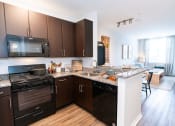 Thumbnail 3 of 26 - a kitchen with an island and a stove and a microwave at Merion Riverwalk Apartment Homes, Shelton, 06484