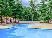 Thumbnail 17 of 27 - A swimming pool surrounded by trees and a deck.