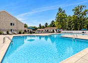 Thumbnail 14 of 20 - A large swimming pool with a building in the background.