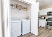 Thumbnail 12 of 28 - a washer and dryer in a kitchen with white cabinets at The Ledges Apartment Homes, Groton, CT, 06340
