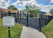 Thumbnail 27 of 32 - A sign on a playground gate provides information about the playground's rules and regulations.