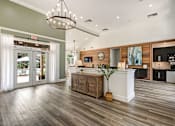 Thumbnail 12 of 34 - A modern kitchen with a wooden floor and a white counter.