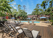 Thumbnail 3 of 34 - A pool surrounded by chairs and trees.