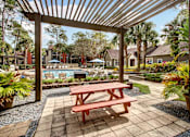 Thumbnail 7 of 34 - A wooden picnic table is in the middle of a patio.