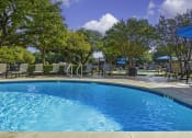 Thumbnail 17 of 17 - a swimming pool with chairs and umbrellas and trees