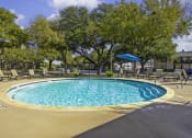Thumbnail 15 of 17 - our resort style swimming pool is surrounded by lounge chairs and trees