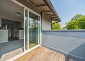 Thumbnail 22 of 28 - a balcony with glass sliding doors and a kitchen in the background