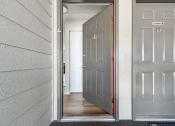 Thumbnail 21 of 28 - an open door leading to a hallway with a hardwood floor