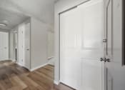 Thumbnail 8 of 28 - a bedroom with white doors and hardwood floors