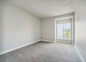 Thumbnail 16 of 28 - a bedroom with a large window and a carpeted floor