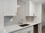 Thumbnail 13 of 41 - an empty kitchen with white cabinets and a sink