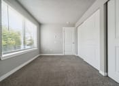 Thumbnail 12 of 28 - a bedroom with a large window and a carpeted floor