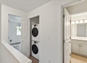 Thumbnail 9 of 41 - a washer and dryer in a living room with a door to a kitchen