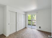 Thumbnail 14 of 41 - an empty living room with white doors and a balcony