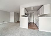 Thumbnail 18 of 28 - a spacious living room with a kitchen in the background