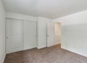 Thumbnail 16 of 41 - a bedroom with white doors and carpeting and white walls