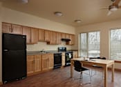 Thumbnail 19 of 27 - A kitchen with black appliances and wooden cabinets.