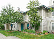 Thumbnail 5 of 24 - A house with a blue door and a green lawn.