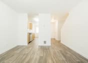 Thumbnail 28 of 41 - a living room and kitchen with white walls and wood flooring