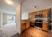 Thumbnail 19 of 21 - A kitchen with wooden cabinets and stainless steel appliances.