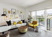 Thumbnail 16 of 34 - a living room with a white couch and yellow chairs and a large window