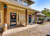 Thumbnail 3 of 24 - A building with a blue door and a red sign on the window.