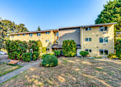 Thumbnail 4 of 17 - Apartment complex with a grassy area in front.