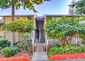 Thumbnail 6 of 9 - A house with a red curb and a tree in front.