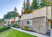 Thumbnail 3 of 9 - A row of houses with a green lawn in front.