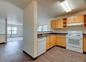 Thumbnail 15 of 33 - A kitchen with wooden floors and white appliances.