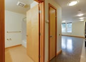 Thumbnail 22 of 22 - A hallway with two doors and a window.