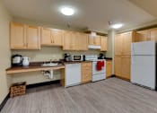 Thumbnail 18 of 18 - A kitchen with wooden cabinets and white appliances.