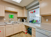 Thumbnail 15 of 24 - A kitchen with a white dishwasher and a sink.