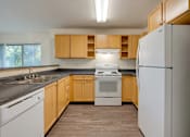 Thumbnail 16 of 33 - A kitchen with wooden cabinets and white appliances.