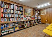 Thumbnail 13 of 18 - A room full of books on shelves and a painting on the wall.