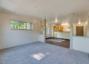 Thumbnail 19 of 33 - A large empty room with a carpeted floor and a window.