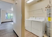 Thumbnail 30 of 33 - A laundry room with a washer and dryer.