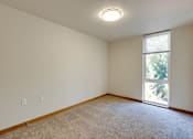 Thumbnail 17 of 22 - A room with a window and a carpeted floor.