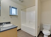 Thumbnail 28 of 33 - A bathroom with a toilet, sink, and bathtub.