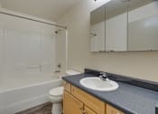 Thumbnail 29 of 33 - A bathroom with a toilet, sink, and bathtub.